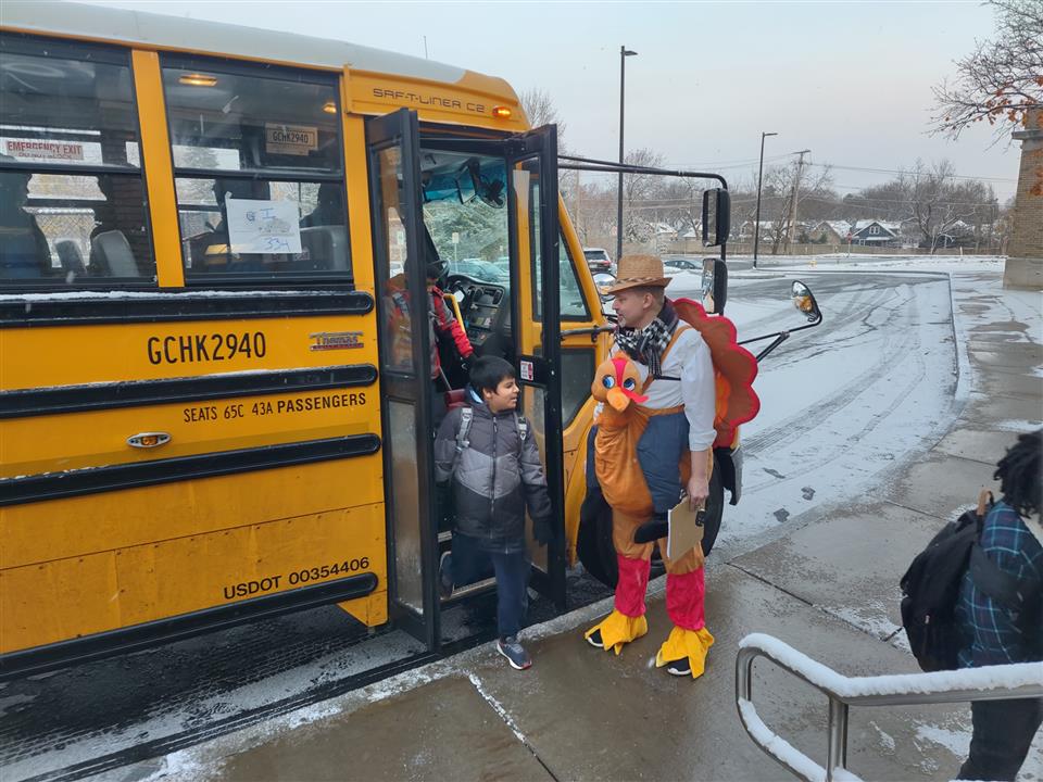 Kid getting off the bus and being greeted by staff