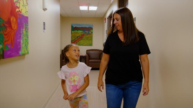 A Child Associate on her way to the playroom with a Primary Project child.
