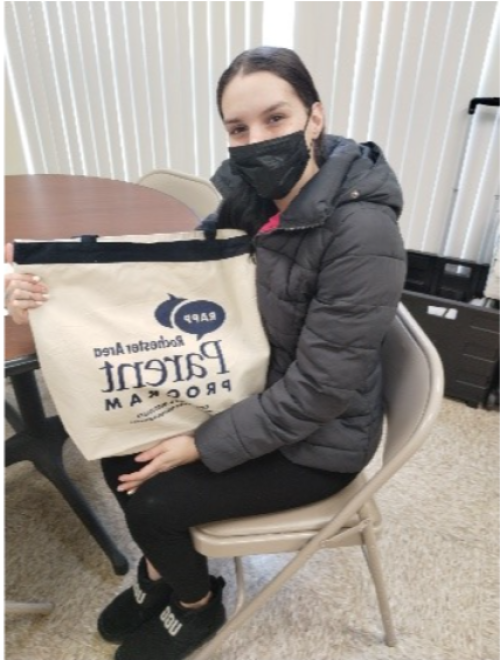 A woman holds up her new RAPP bag!