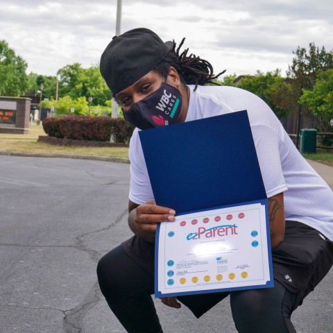 A dad holds up his completion certificate.