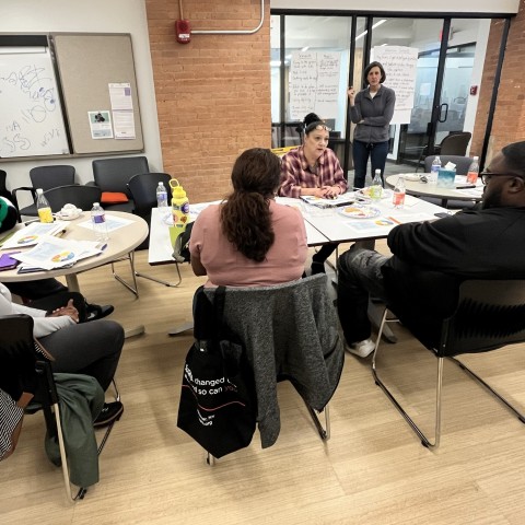 A group of parents around a table collaborating.